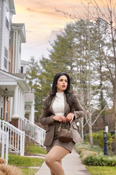a lady in a white sweater and a brown suit